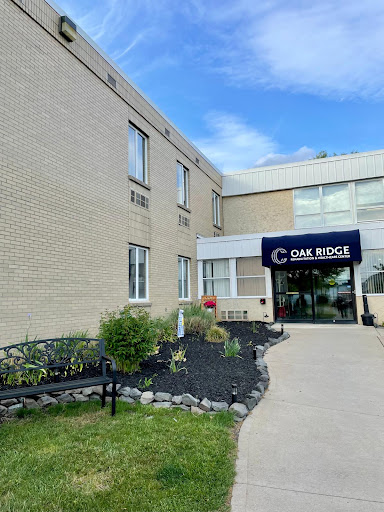 A view of a two-story building showcasing its entrance and landscaped area.