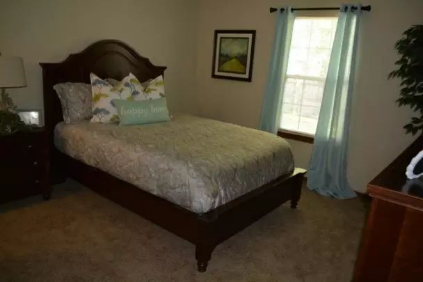 A cozy bedroom with a neatly made bed and soft lighting.