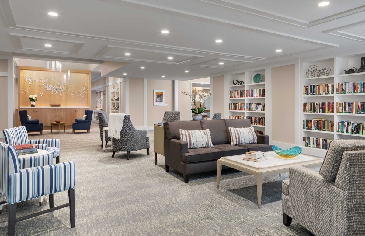 A modern living room with comfortable seating, bookshelves, and a coffee table.