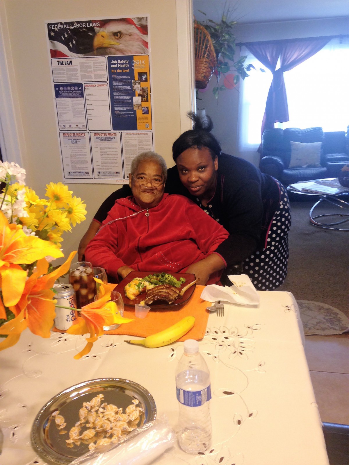 A joyful family celebration with a cake and colorful flowers on the table.