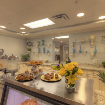 A cozy bakery interior with pastries and flowers on display.