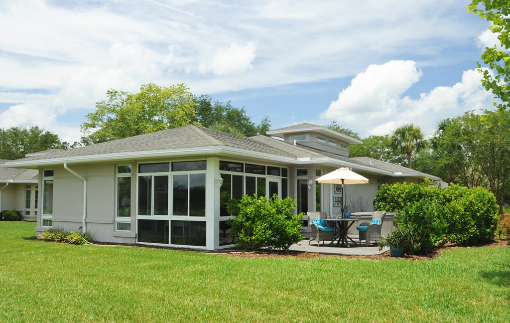 A cozy residential house with a spacious backyard and a patio area.