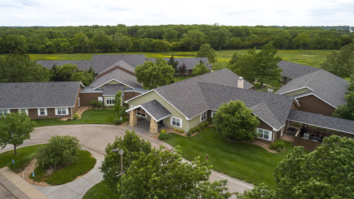 Aerial view of a residential area surrounded by lush greenery and trees.