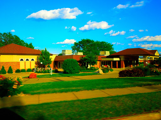 A vibrant view of a community building surrounded by greenery and blue skies.