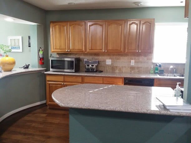 Modern kitchen with wooden cabinets and a granite countertop.