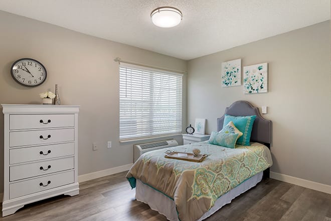 A stylish bedroom featuring a single bed with modern decor and ample natural light.
