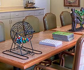 A conference table set up for a bingo game with a cage of colored balls and seating.