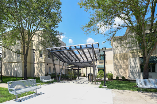 A welcoming entrance with a modern canopy surrounded by greenery.