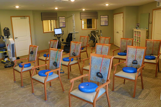 A rehabilitation area equipped with chairs and exercise equipment for physical therapy sessions.