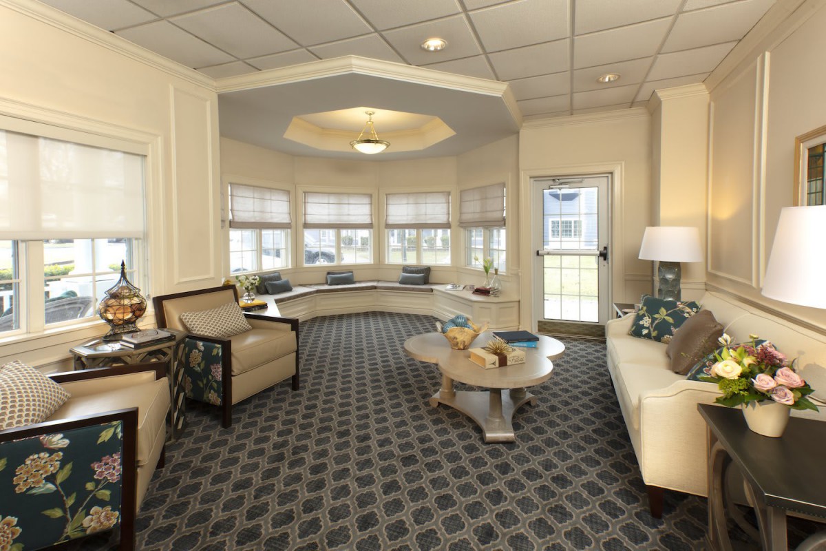 A cozy living room with comfortable seating and stylish decor, featuring large windows that let in natural light.