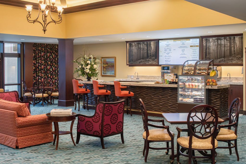 A cozy lobby area featuring a bar with seating and elegant furniture.