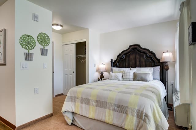 A cozy bedroom with a large bed, decorative headboard, and soft lighting.