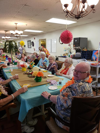 Seniors enjoying a vibrant community gathering with festive decorations and lively conversation.
