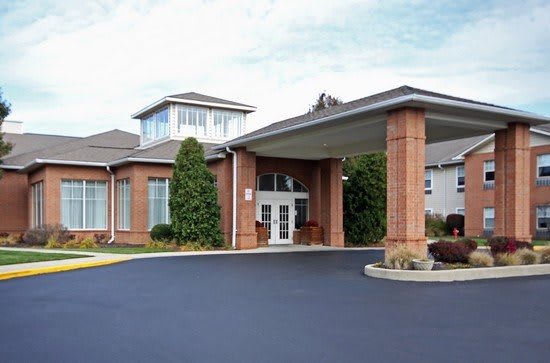 A brick building with a covered entrance, possibly a hotel or similar establishment.