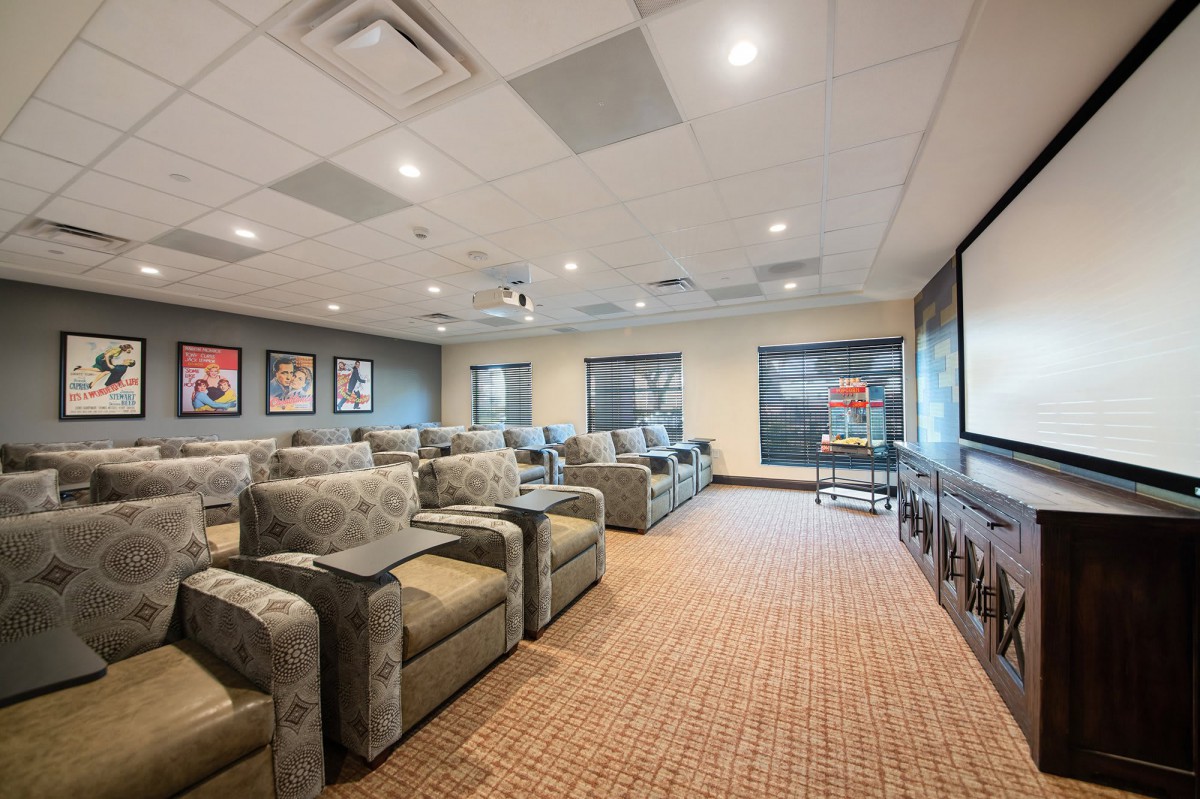 A cozy home theater room with comfortable seating and a large projector screen.