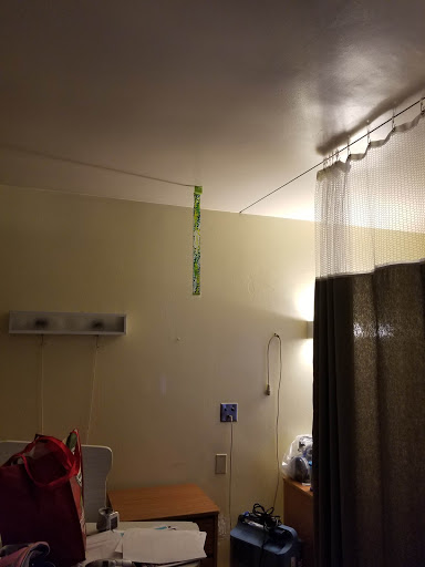 A view of a hospital room showcasing the ceiling, curtains, and some medical equipment.