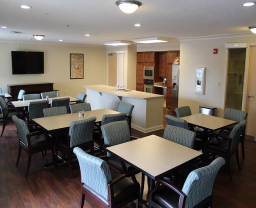 A spacious dining area in a community facility, featuring several tables and chairs.