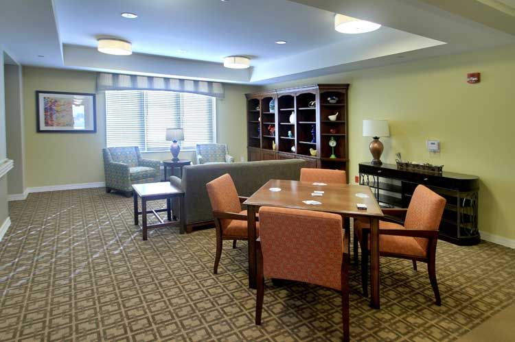 A cozy living room with comfortable seating, a wooden table, and a well-stocked bookshelf.