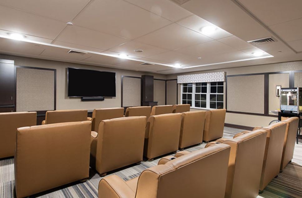 A cozy theater room with rows of comfortable seating and a large television screen.