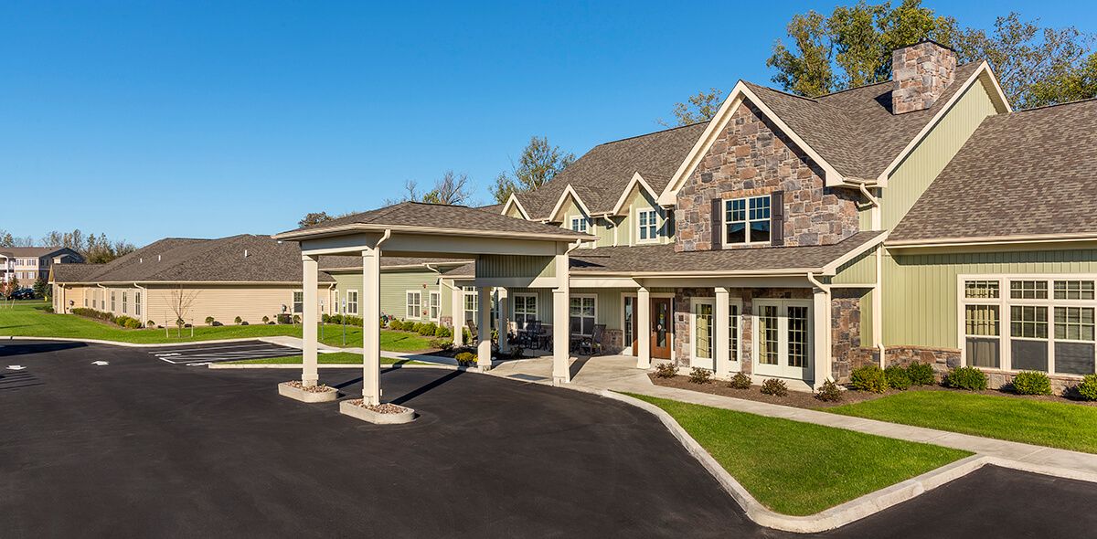 A large residential house with a covered driveway and well-maintained landscaping.