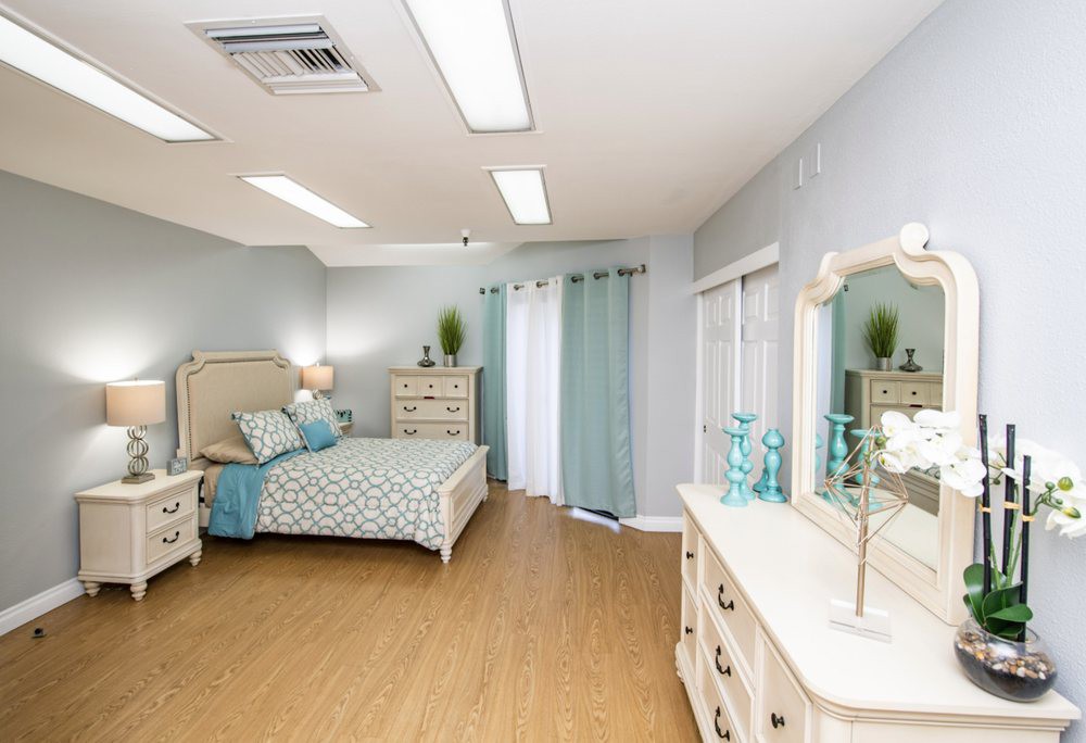 A spacious bedroom with light-colored furniture and a cozy ambiance.