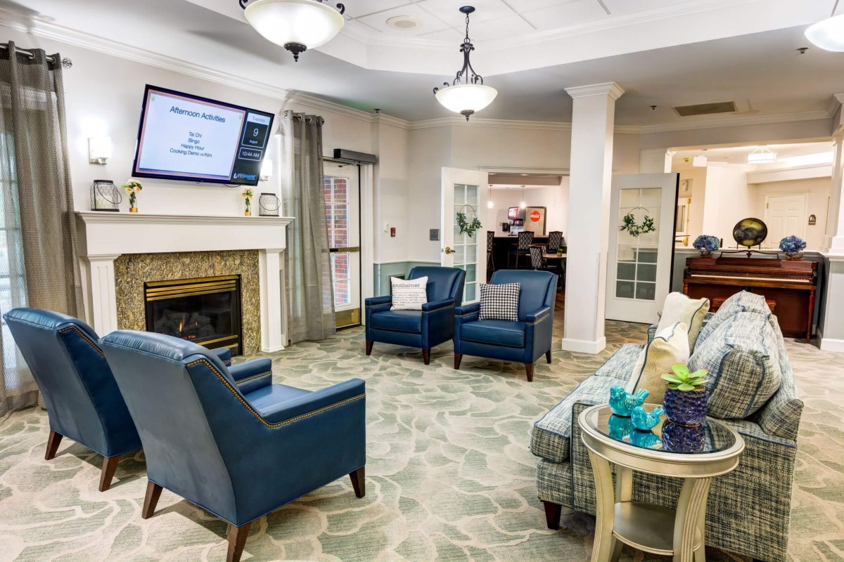 A cozy living room with modern furniture and a fireplace, creating a comfortable seating area.
