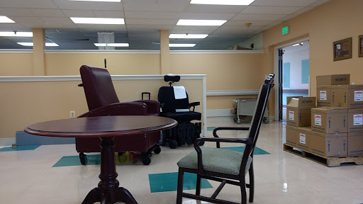 A waiting area in a medical facility featuring various chairs and a table.