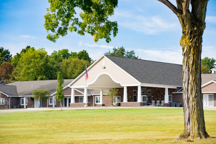 A modern building with a spacious lawn and clear sky.