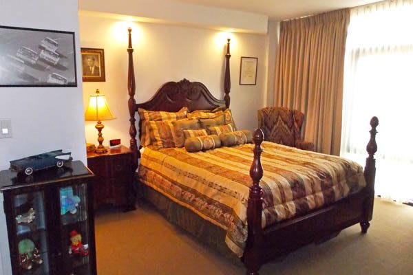A warmly lit bedroom with a four-poster bed and classic furnishings.