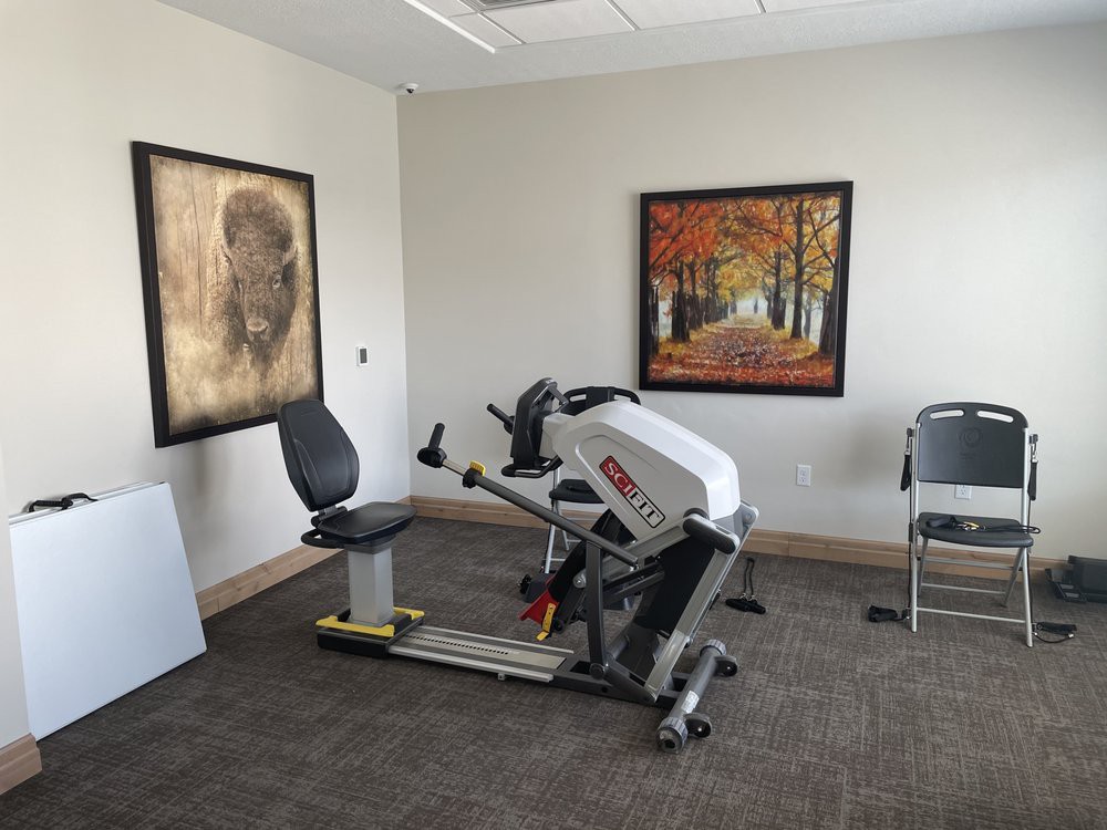 An office space with exercise equipment and artwork on the walls.