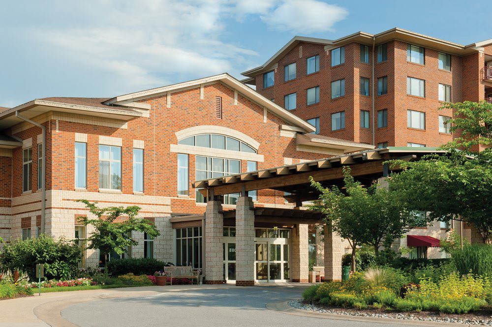 A brick hotel building with a prominent entrance and landscaped surroundings.
