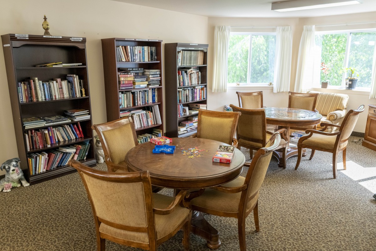 A cozy reading room with bookshelves and tables arranged for leisure.