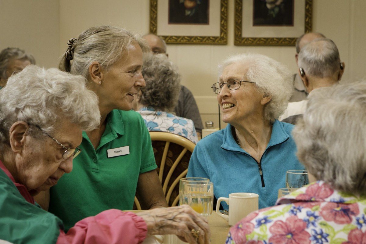 A group of seniors enjoying a lively conversation at a social gathering.