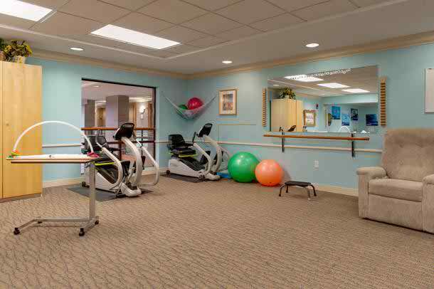 A well-equipped fitness room featuring stationary bikes, exercise balls, and mirrors.