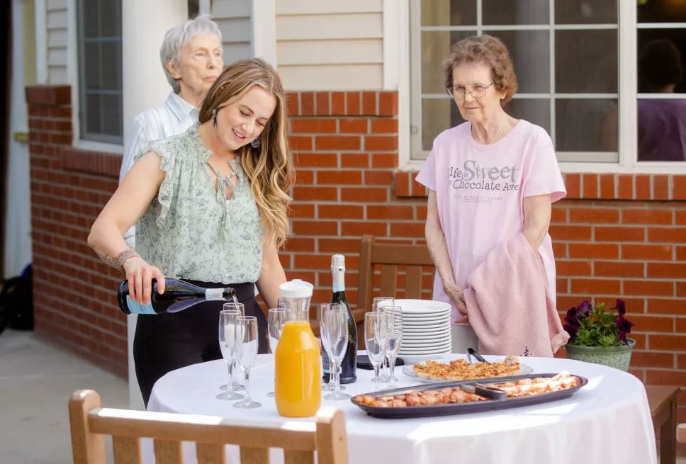A group of people enjoying an outdoor gathering with food and drinks.