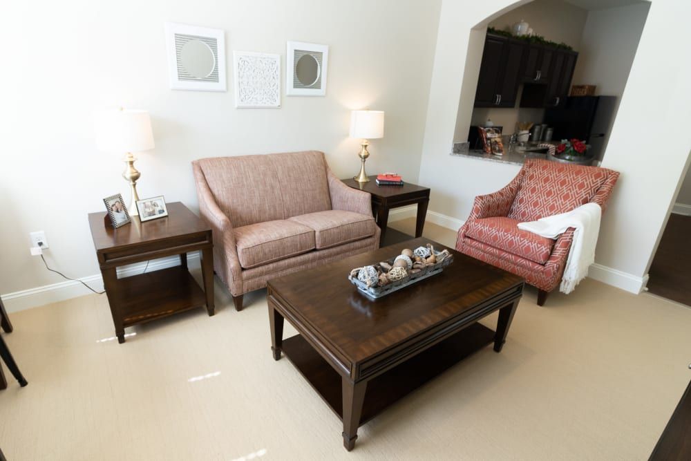 A cozy living room with a sofa, armchair, and wooden coffee table.