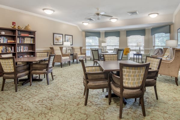 A cozy interior space with multiple tables and chairs, tastefully decorated.