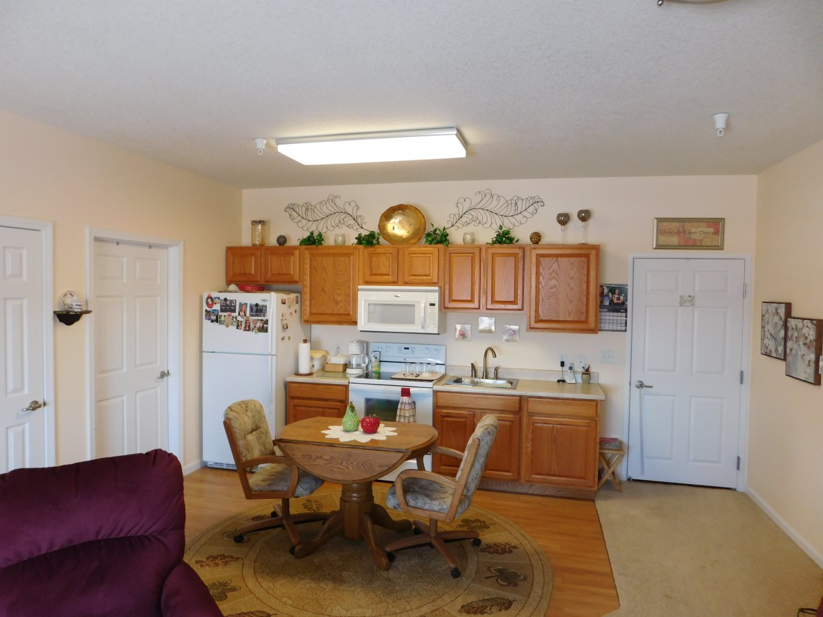 A cozy kitchen and dining area with wooden cabinets and a small round table.