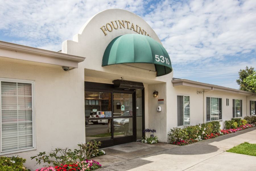 The entrance to a commercial building with an arched canopy and green awning.