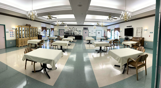 A spacious dining hall featuring neatly arranged tables and chairs, waiting to welcome guests.