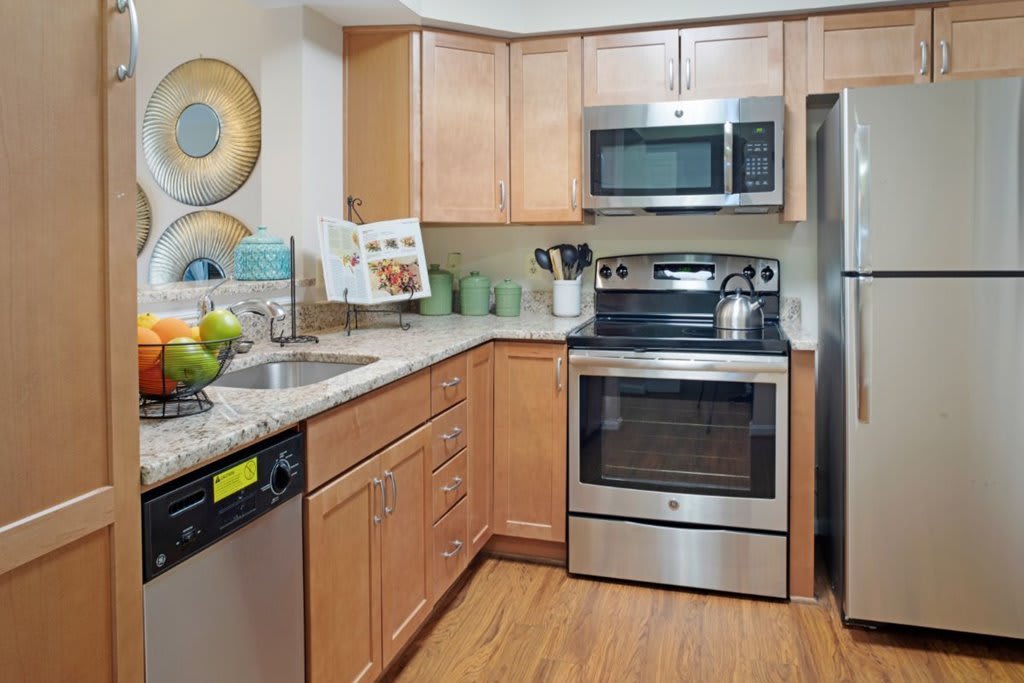 A modern kitchen with stainless steel appliances and wooden cabinets.