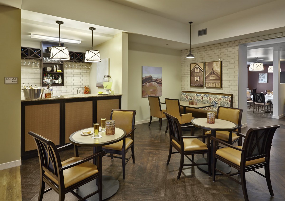 A cozy cafe with several tables and chairs, warm lighting, and inviting decor.