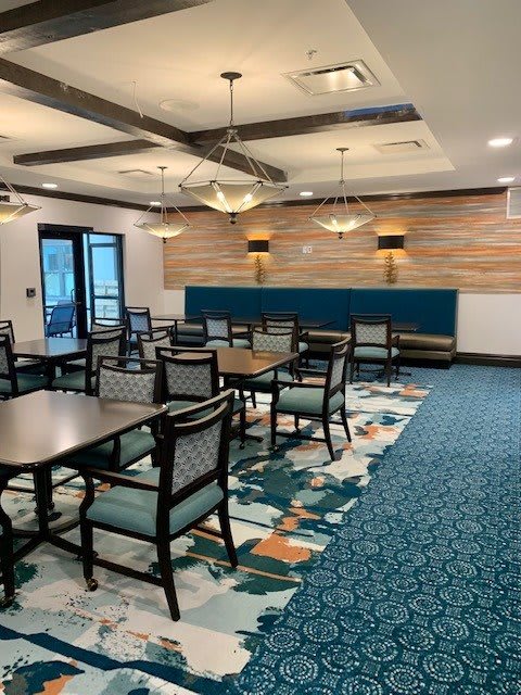 A modern dining area with tables, chairs, and stylish lighting fixtures.