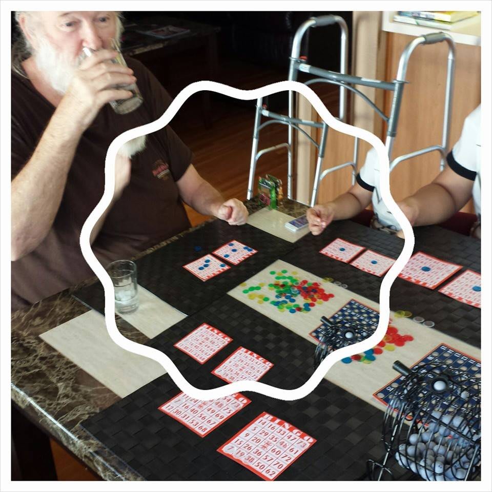 People playing a card game at a table indoors.