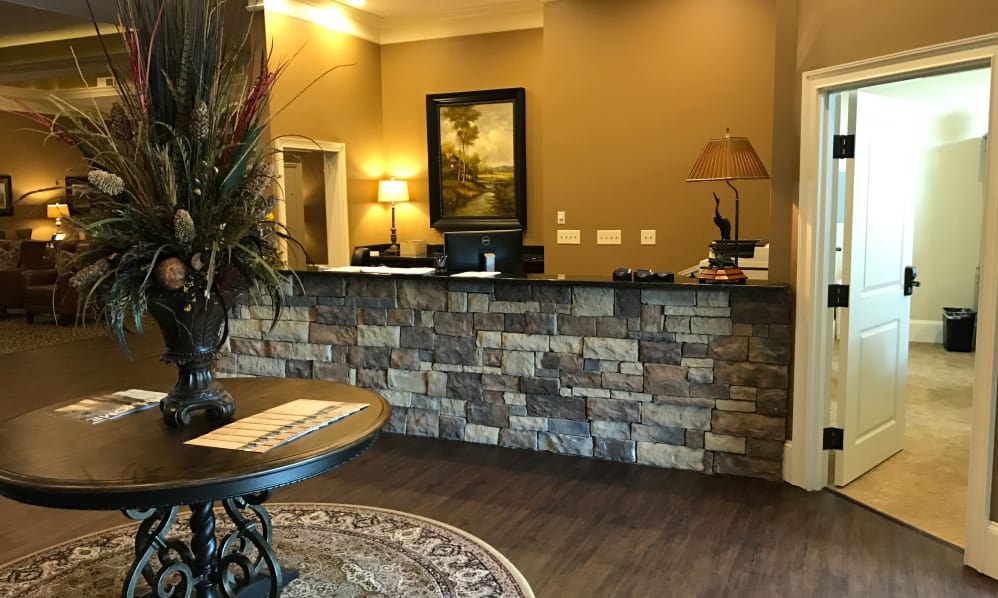 A warmly lit hotel reception area with a stone-front desk and decorative elements.