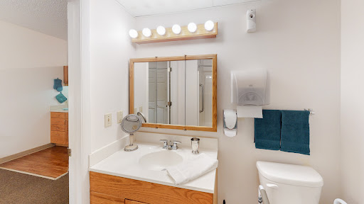 A clean and well-lit bathroom vanity area with a mirror, sink, and modern fixtures.