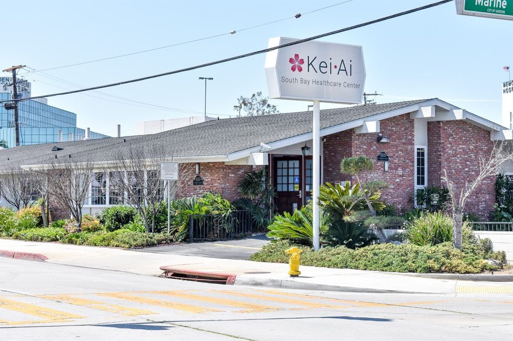 Exterior view of a brick restaurant with signage and landscaping.