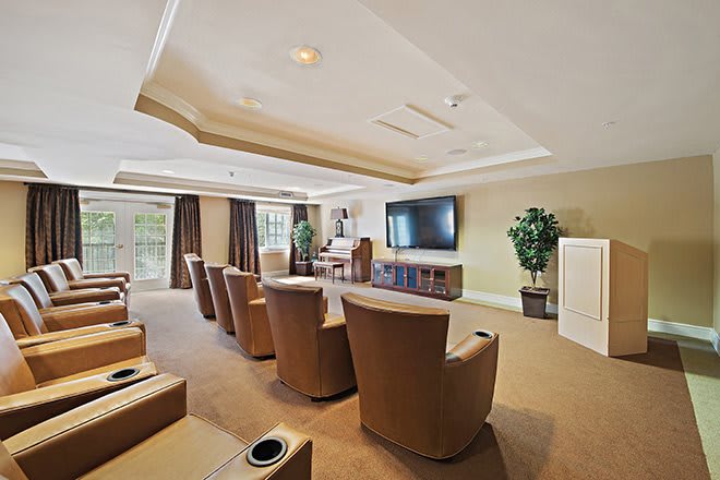 A cozy home theater room with reclining chairs and a large screen TV.