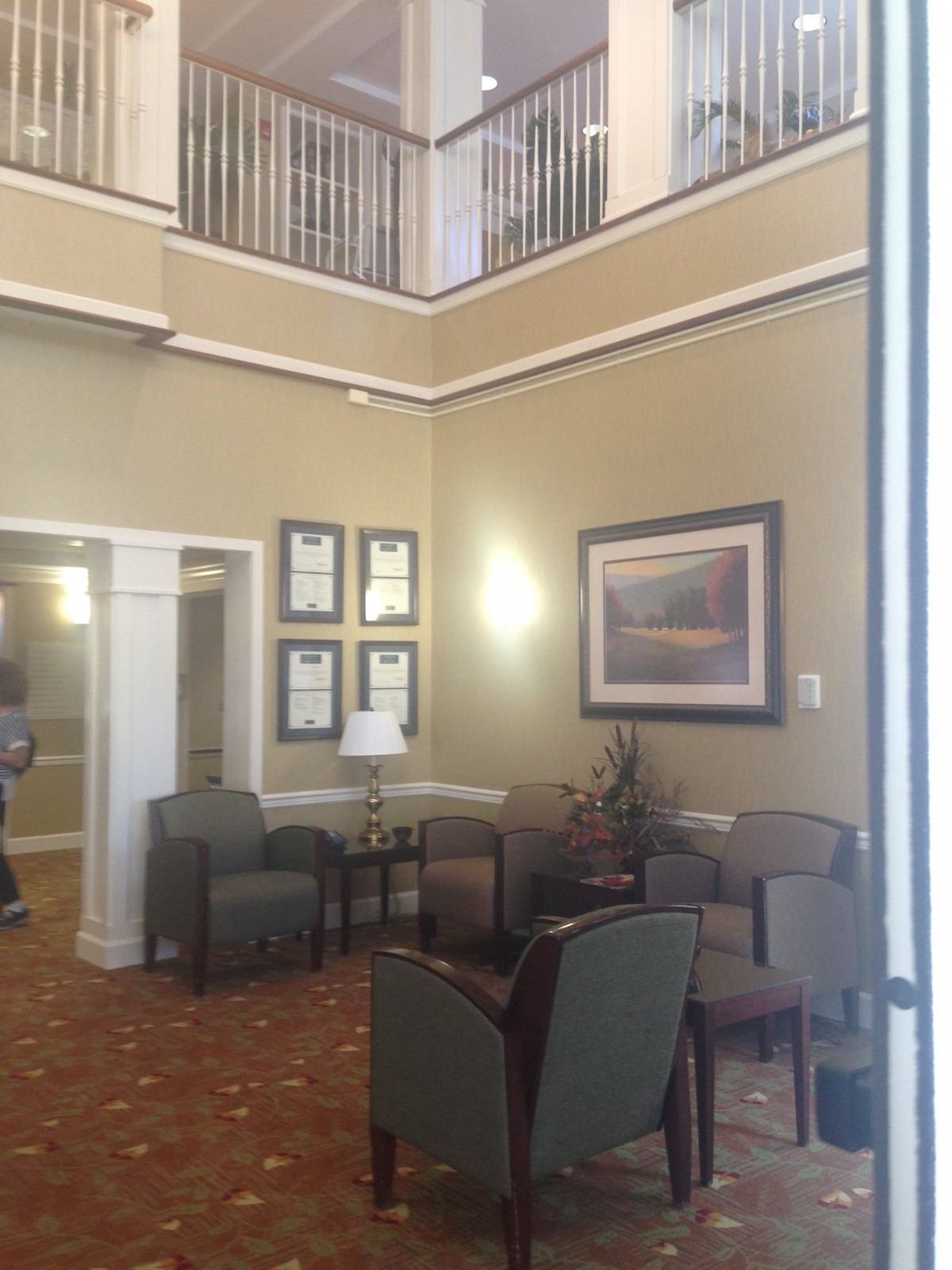 A spacious lobby area with comfortable seating and decorative paintings on the walls.