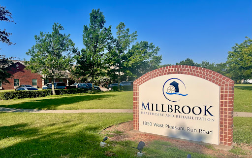 Entrance to Millbrook Community, showcasing a welcoming sign and lush surroundings.